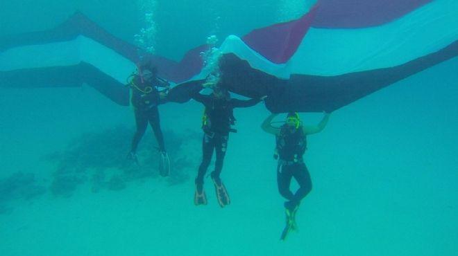 مصريون يدخلون جينس برفع “أكبر علم لمصر” تحت الماء