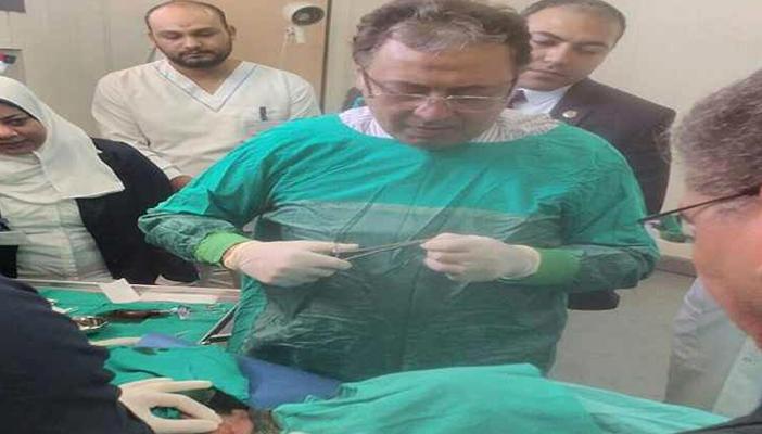 بالفيديو.. شاهد وزير الصحة يجري عملية جراحية والحرس خلفه