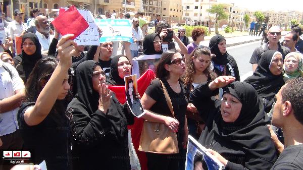 أمهات الشهداء يرفعون الكروت الحمراء والأحذية أمام منزل مرسي